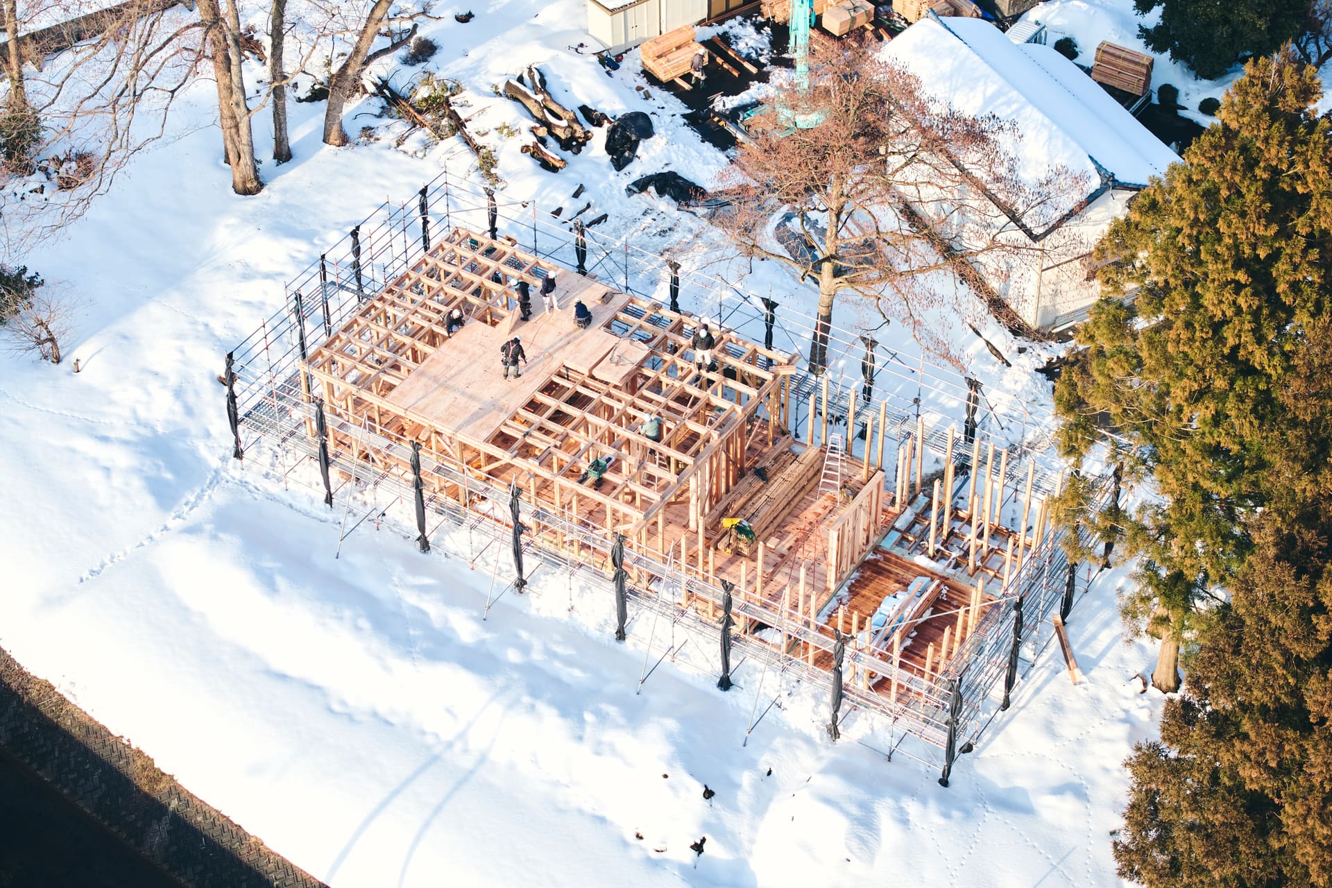 雪のなかで建ち上がるNéの木架構